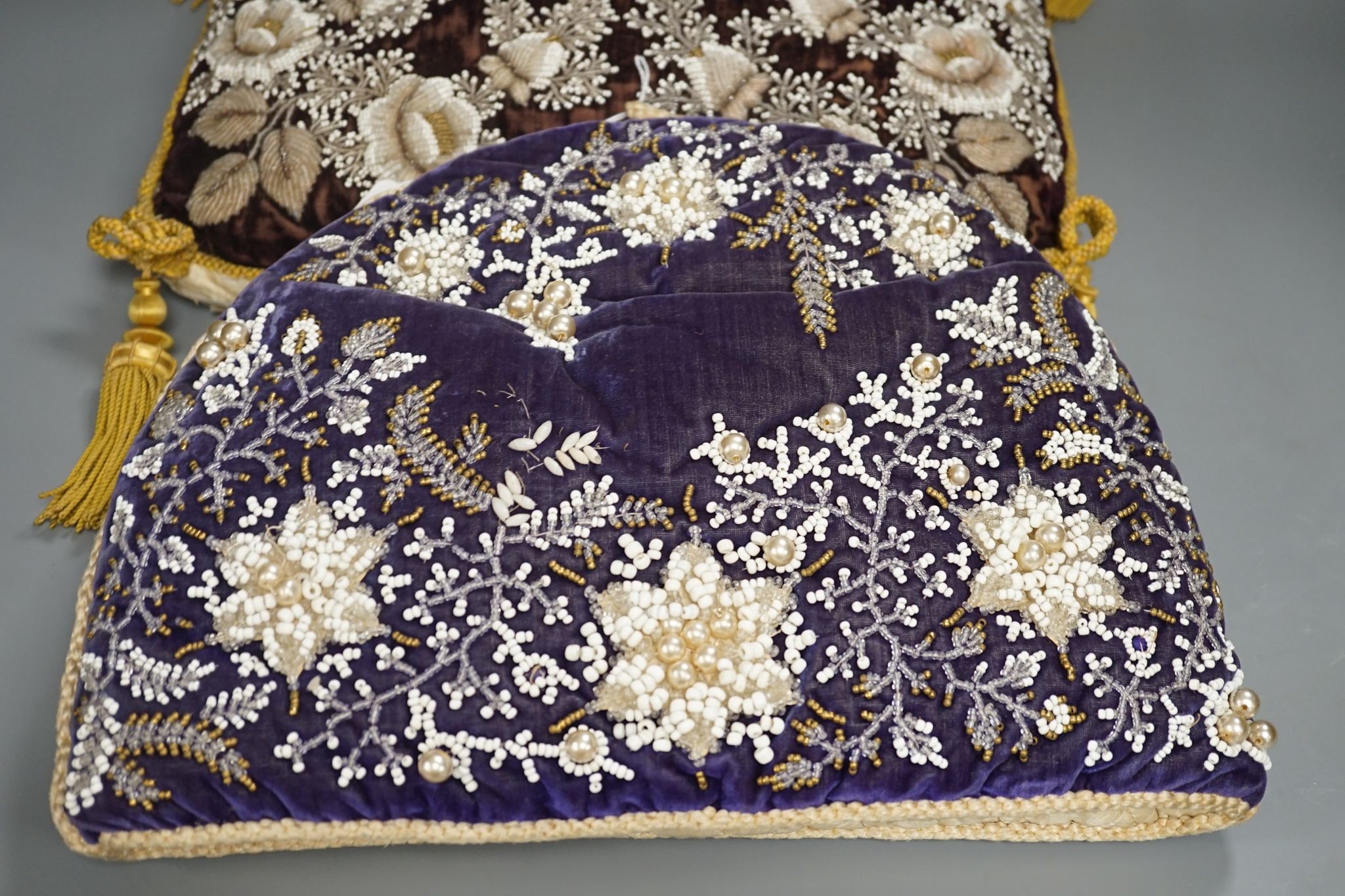 A 19th century Berlin bead worked tea cosy on purple velvet with a similar cushion, Cushion 36 cms wide x 32 high.